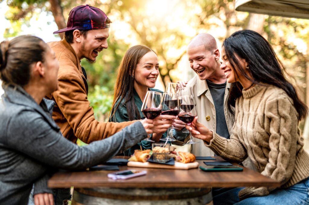 Group,Of,Smiling,Friends,Drinking,And,Toasting,Red,Wine,In